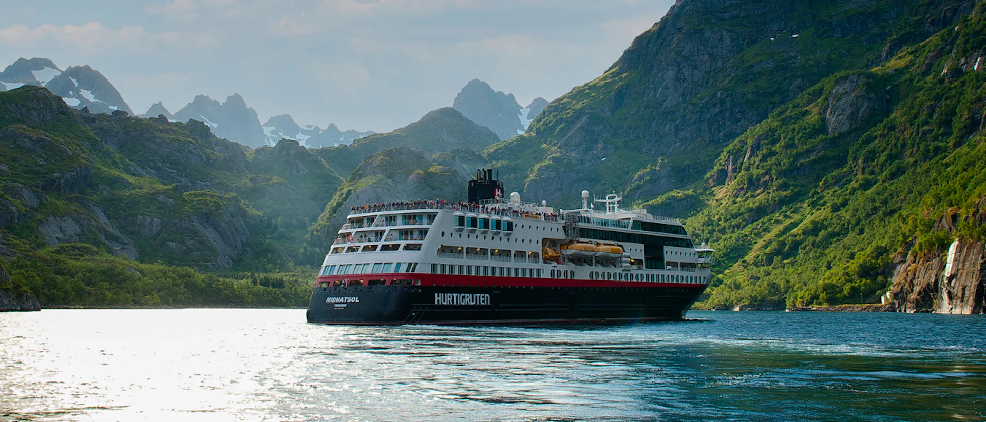 Kryssa ombord Hurtigrutens MS Midnatsol. Bilden visar MS Midatsol i en fjord.