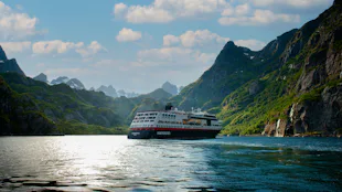 Kryssa ombord Hurtigrutens MS Midnatsol. Bilden visar MS Midatsol i en fjord.