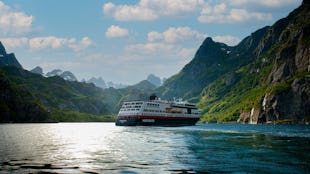 Kryssa ombord Hurtigrutens MS Midnatsol. Bilden visar MS Midatsol i en fjord.